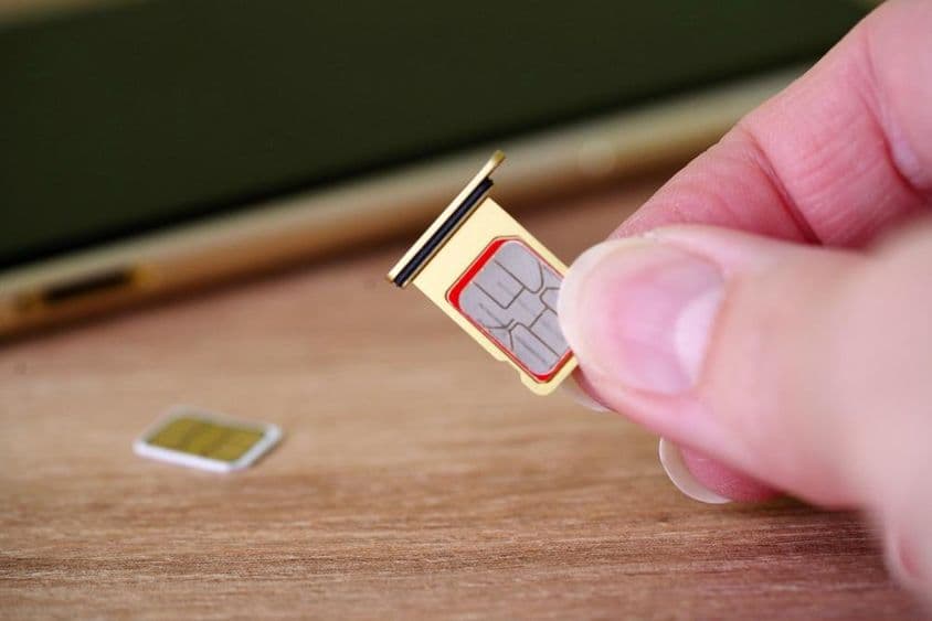 将SIM卡插入手机背面的人员。