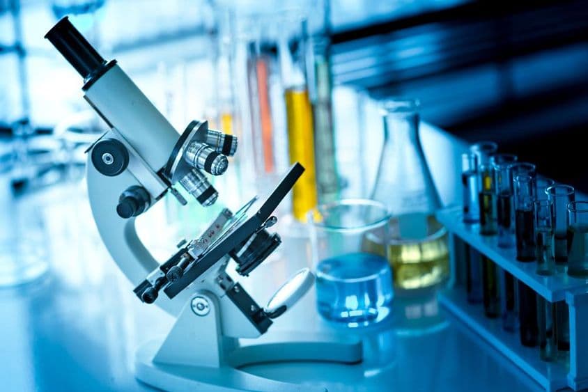 桌上的显微镜与化学试管和玻璃器皿。