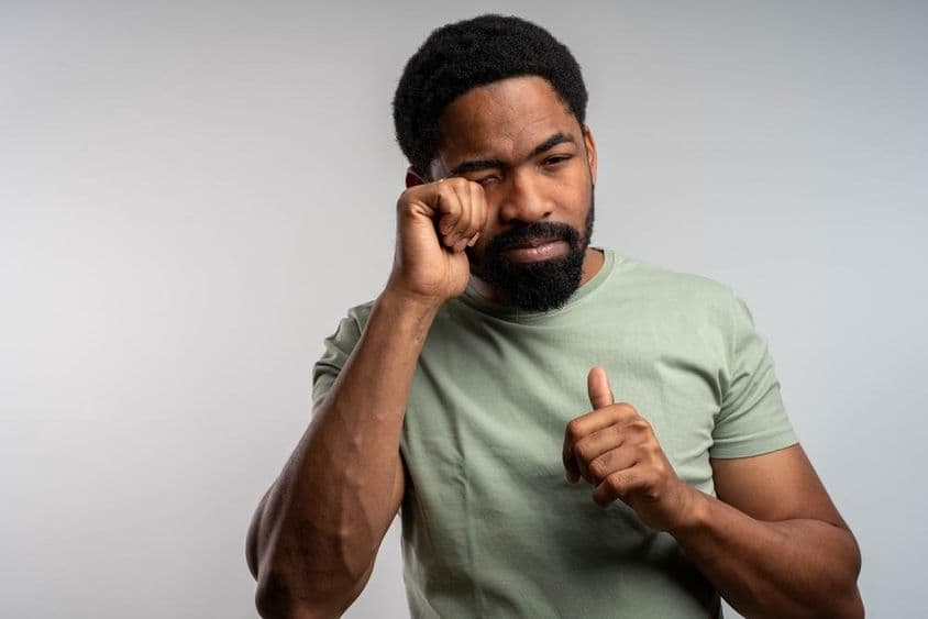 一个人不舒服地揉眼,感觉烦躁和疲劳。