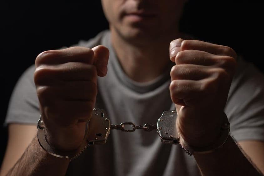 双手戴着手铐。