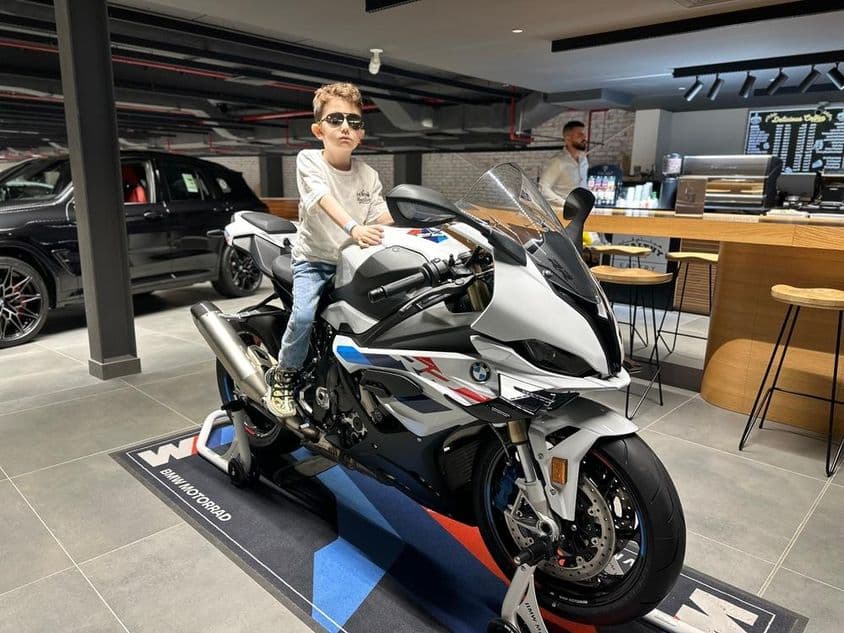 戴墨镜的男孩坐在宝马摩托车上